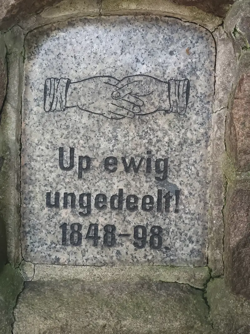 Alter Gedenkstein mit zwei verschränkten Händen und der Inschrift Up ewig ungedeelt 1848–98